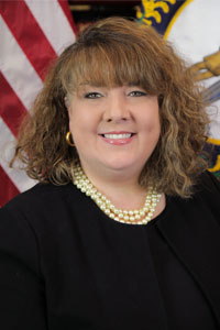 Portrait of Heather Quinn in front of the American and Kentucky flags.